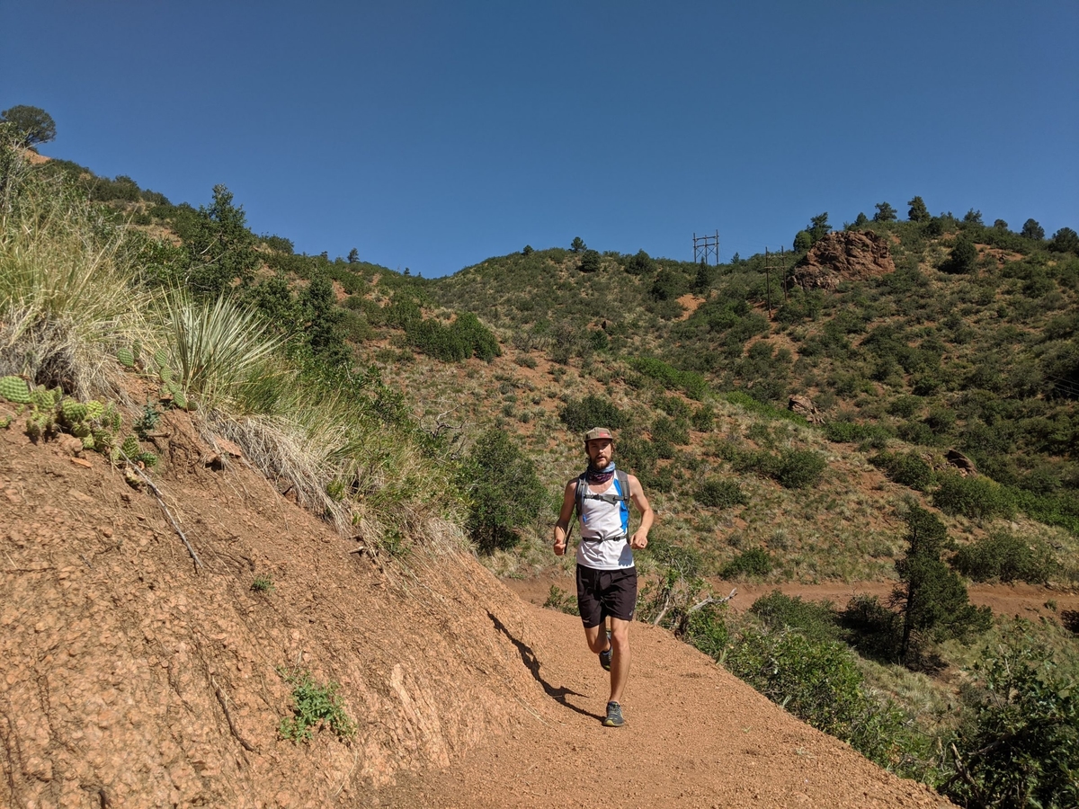 Runner transitioning through different shoe types on a trail